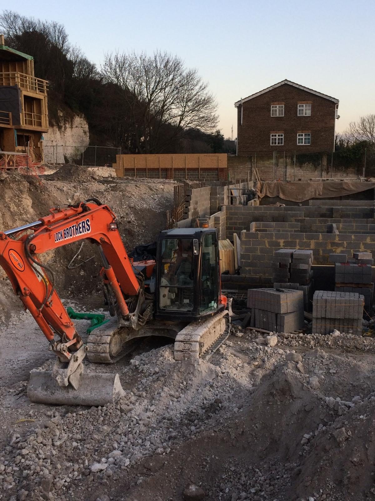 Groundworks excavation with excavator and new foundations under construction