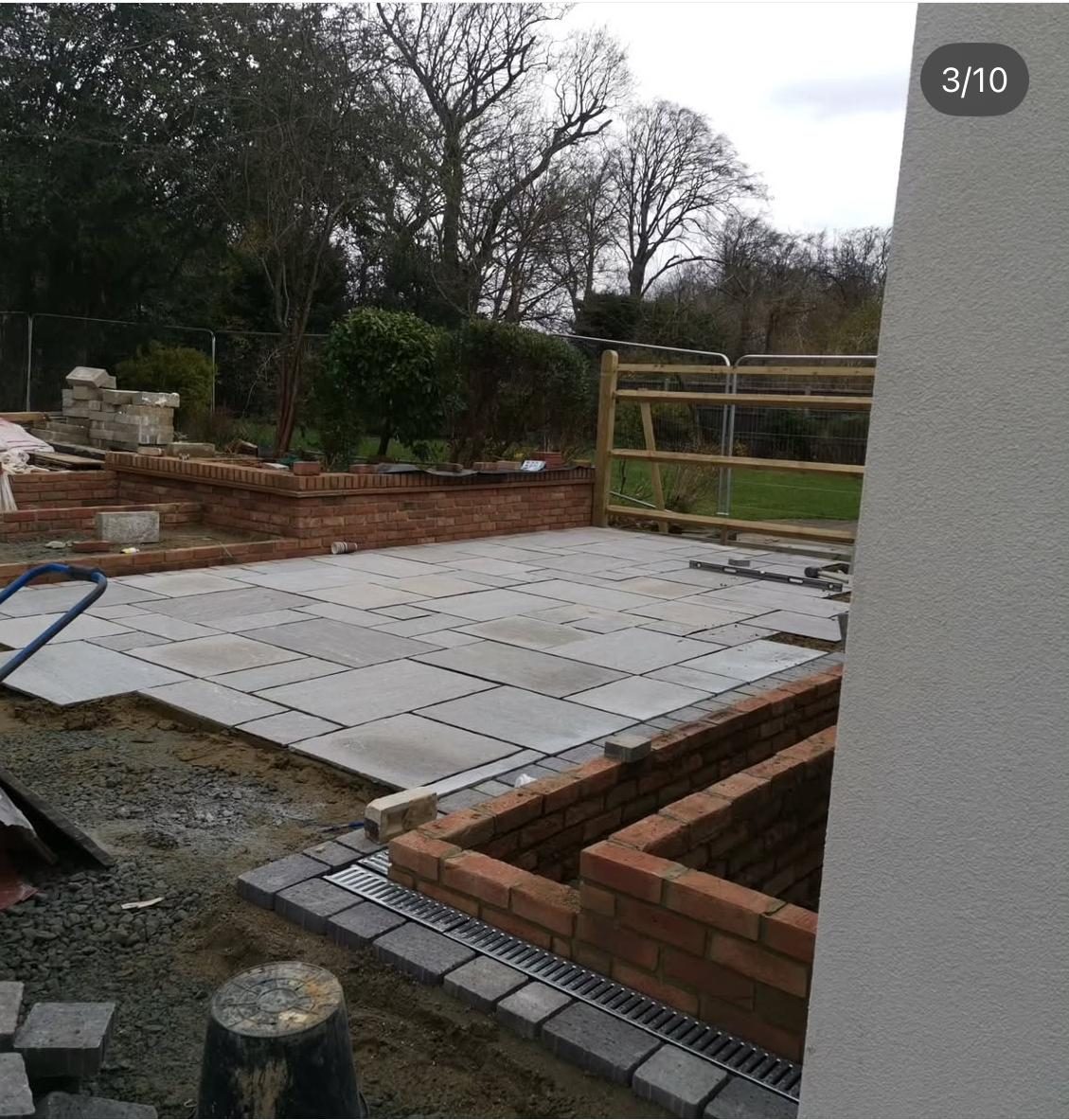 New paved patio with brick raised planters and drainage detail